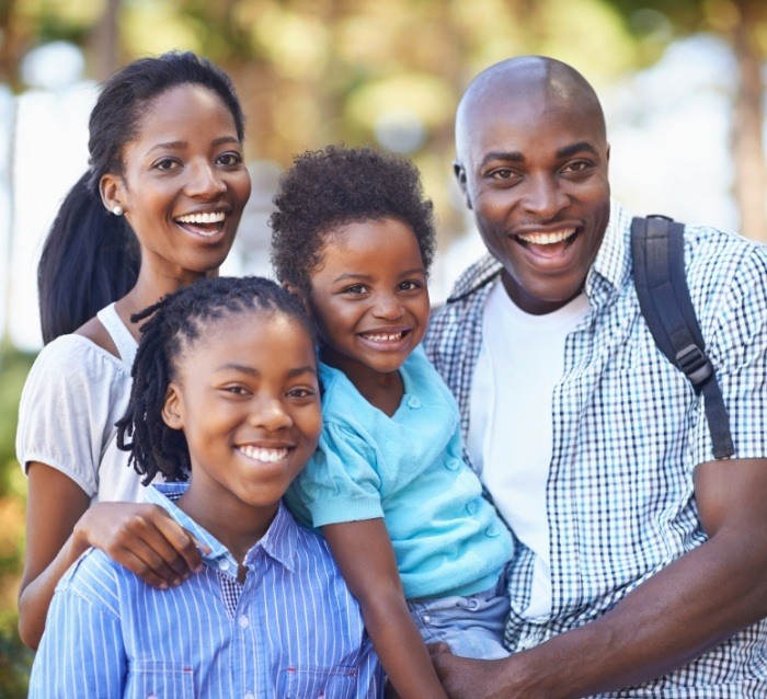 Family of four smiling outdoors