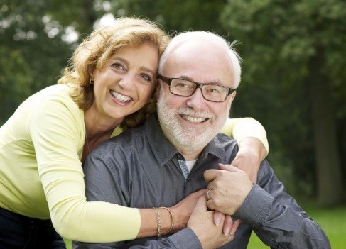 Older couple smiling after visiting their dentist