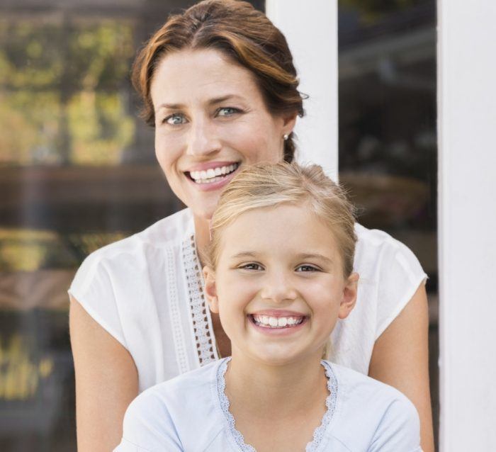 Mother and child smiling after visiting their cosmetic dentist