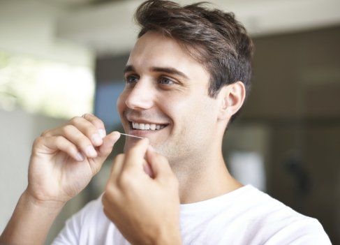 Man flossing to prevent dental emergencies