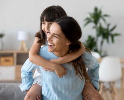 Mother and child laughing together and dental office reception desk