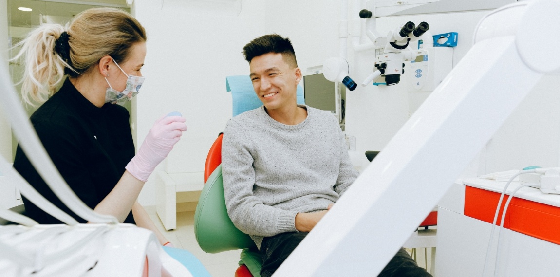 Dental patient smiling at dentistry team member