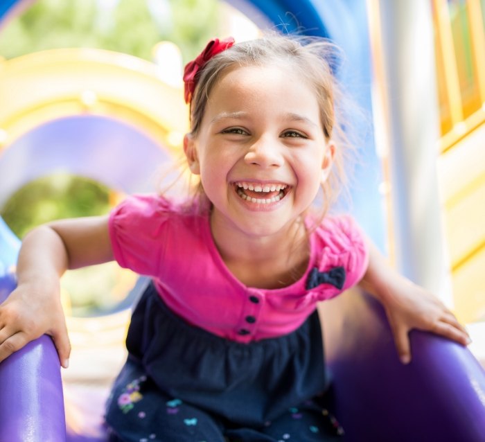 Child smiling after visiting her dentist in Anaheim California