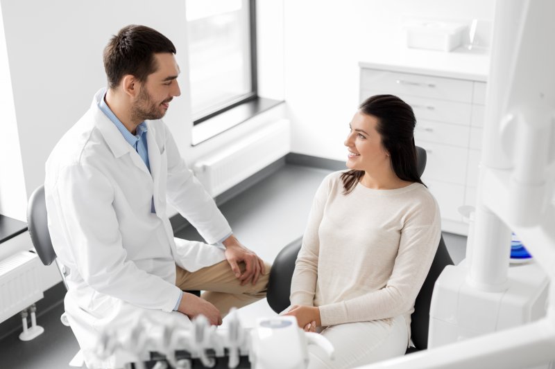 person smiling while talking to dentist